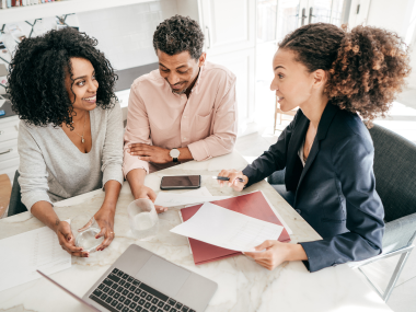 Office staff discussing together with computer and paper