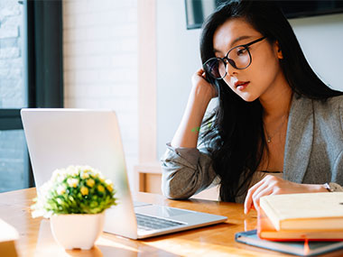 Woman examining information on laptop