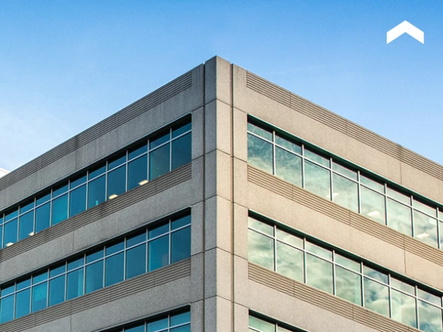 Top of a tall building with a blue sky background